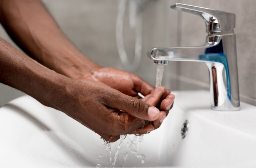 A close-up of a person's hands being washed using running water.