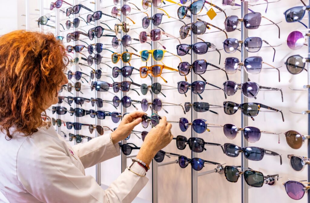 A person browsing through a selection of sunglasses at an optometry office